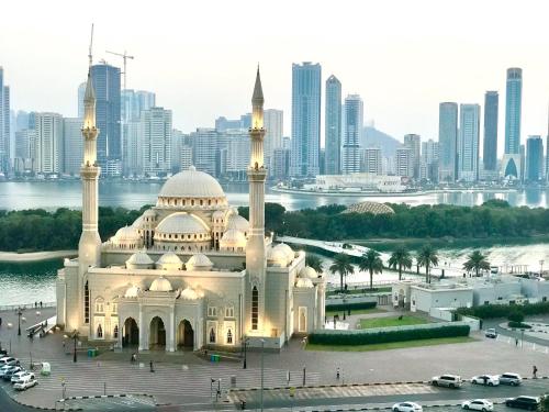 una mezquita con una ciudad en el fondo en غرفة نوم بالشارقة, en Sabkhah