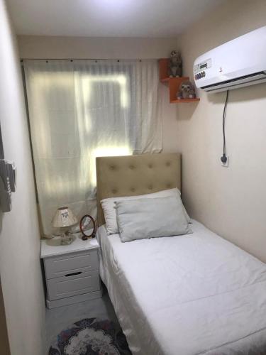 a small bedroom with a bed and a window at غرفة نوم بالشارقة in Sabkhah