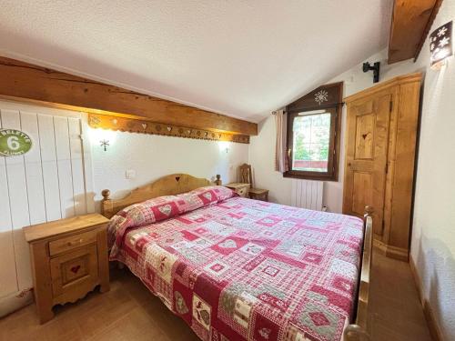 une chambre avec un lit avec une couette rouge dans l'établissement Charmant appartement au pied des pistes avec piscine et parking - FR-1-505-13, à Flumet