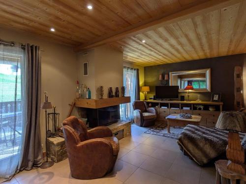 un salon avec un canapé et une cheminée dans l'établissement Ski au pied, duplex rénové 4 ch, terrasse, cheminée, tout confort - FR-1-459-22, à La Clusaz