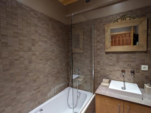 une salle de bain avec une baignoire, un lavabo et une douche dans l'établissement Ski au pied, duplex rénové 4 ch, terrasse, cheminée, tout confort - FR-1-459-22, à La Clusaz
