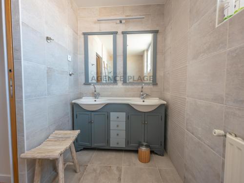 une salle de bain avec un lavabo et un miroir dans l'établissement Maison 3 chambres avec jardin et parking à La Chaume, proche plages et commerces - FR-1-197-556, à Les Sables-dʼOlonne