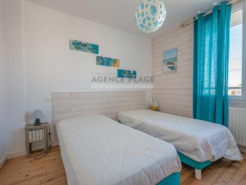 une chambre avec deux lits et une fenêtre dans l'établissement Maison 3 chambres avec jardin et parking à La Chaume, proche plages et commerces - FR-1-197-556, à Les Sables-dʼOlonne