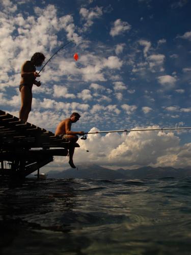 two people fishing on a dock in the water at Florida Blue Bay Resort & Spa in Psathopirgos