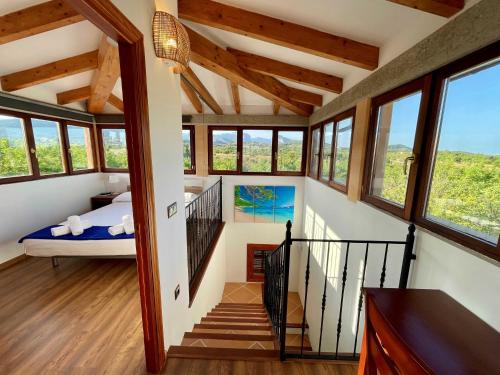 a room with a bed and a staircase with windows at Casa Moragues in Santa Maria del Camí