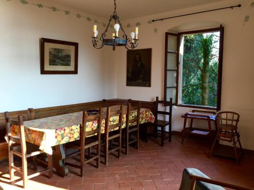 a dining room with a table and chairs and a window at Agriturismo Cervano in Toscolano Maderno