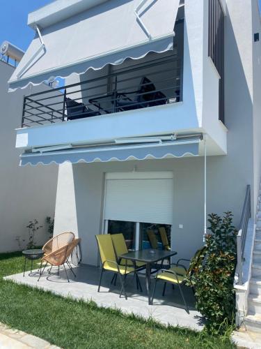 a patio with a table and chairs and a balcony at Diamond Apartment 1 Ofrinio Beach in Ofrínion
