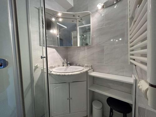 une salle de bain blanche avec un lavabo et un miroir dans l'établissement Appartement 2 pièces cabine, piscine, parking, 5 couchages - Port Camargue - FR-1-250-234, au Grau-du-Roi