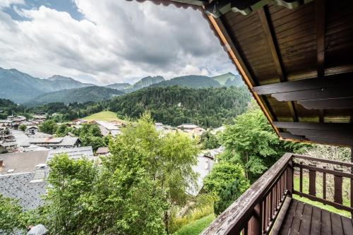 a balcony with a view of a town and mountains at Chalet Chez Juju in Abondance