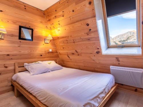 Un dormitorio con una cama en una habitación de madera. en Appartement 3 pièces pour 6 pers. avec balcon et wifi, proche pistes et commerces à Avoriaz - FR-1-314-152, en Morzine