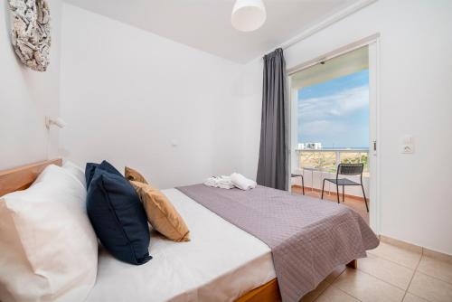 a bedroom with a bed with a view of a balcony at Einalia Holiday Homes near the Beach in (( Elaiónas ))