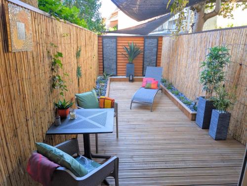 a patio with chairs and a table on a wooden deck at Studio avec terrasse privative in Albi
