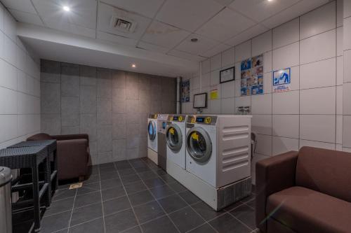 a laundry room with two washing machines and a couch at l'Ours Bleu A35 - Ski in Ski out - Happy Rentals in Vallorcine