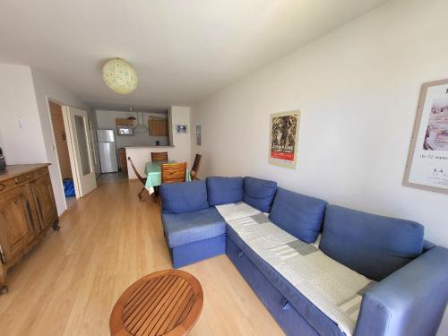 un salon avec un canapé bleu et une table dans l'établissement T2 avec Balcon, Parking Privé, à 800m de la Plage et 500m des Commerces - Les Sables d'Olonne - FR-1-92-699, à Les Sables-dʼOlonne