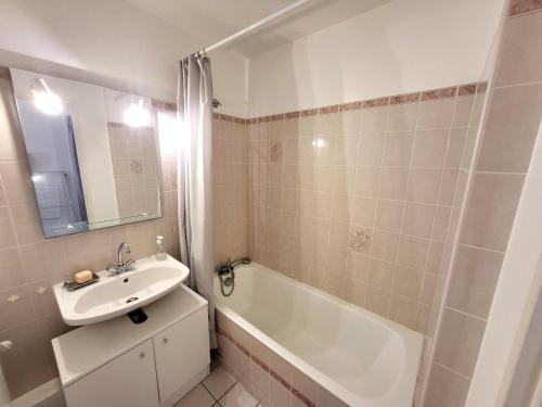 une salle de bain avec un lavabo et une baignoire et un lavabo dans l'établissement T2 avec Balcon, Parking Privé, à 800m de la Plage et 500m des Commerces - Les Sables d'Olonne - FR-1-92-699, à Les Sables-dʼOlonne