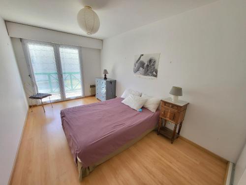 - une chambre avec un lit et une table de chevet dans l'établissement T2 avec Balcon, Parking Privé, à 800m de la Plage et 500m des Commerces - Les Sables d'Olonne - FR-1-92-699, à Les Sables-dʼOlonne