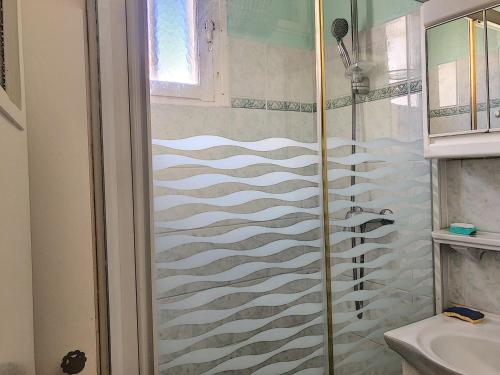 une douche avec une porte vitrée dans une salle de bain dans l'établissement Appartement RDC bord de mer, 500m des commerces - FR-1-361-499, à Jullouville