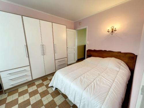 - une chambre avec un lit et des armoires blanches dans l'établissement Appartement RDC bord de mer, 500m des commerces - FR-1-361-499, à Jullouville