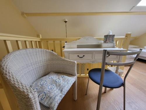 une chaise et un bureau avec un téléphone dans une pièce dans l'établissement Appartement 2 pièces avec mezzanine chez plage, centre-ville et garage privé - FR-1-92-704, à Les Sables-dʼOlonne