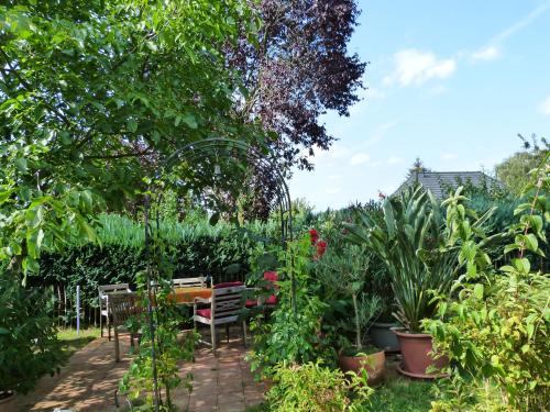 un giardino con tavolo, sedie e piante di Eisvogel- Ferienwohnung a Marienfelde
