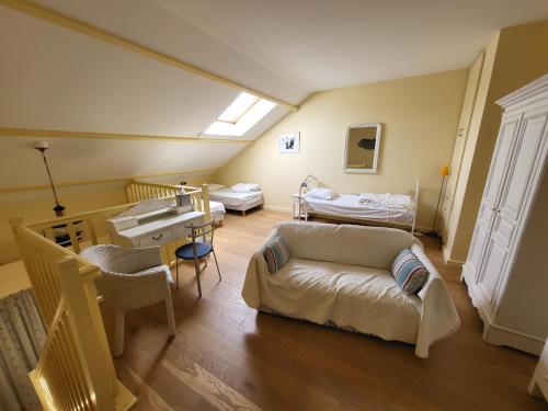 une chambre d'hôpital avec deux lits et un canapé dans l'établissement Appartement 2 pièces avec mezzanine chez plage, centre-ville et garage privé - FR-1-92-704, à Les Sables-dʼOlonne