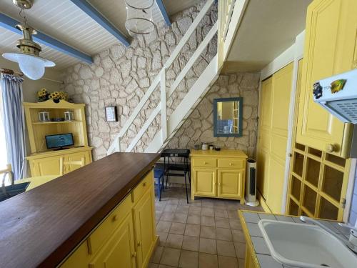 - une cuisine avec des placards jaunes et un évier dans l'établissement Charmant Pavillon Familial avec Terrasse et Mezzanine - Proche Plage - Saint-Cyprien Plage - FR-1-106-86, à Saint-Cyprien