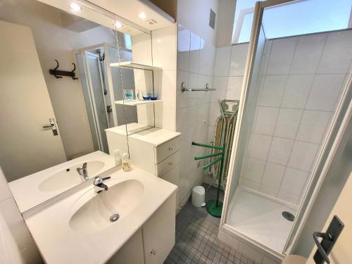 une salle de bain blanche avec un lavabo et une douche dans l'établissement T2 agréable aux Sables - Face mer, proche plage & commerces, balcon, animal admis - FR-1-92-629, à Les Sables-dʼOlonne