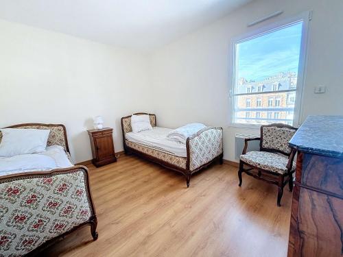 - une chambre avec 2 lits, 2 chaises et une fenêtre dans l'établissement Appartement 3P avec Ascenseur, Parking et Proche Plage à Granville - FR-1-361-59, à Granville