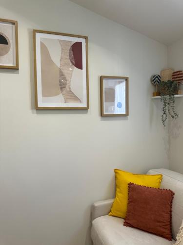 - un salon avec un canapé et des photos sur le mur dans l'établissement Charmant studio près de Roissy CDG, au Mesnil-Amelot