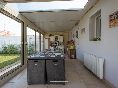 - une cuisine avec un îlot dans une chambre dotée de fenêtres dans l'établissement Maison 3 chambres aux Sables-d'Olonne avec jardin clos, véranda et proche commerces et plages. - FR-1-197-576, à Les Sables-dʼOlonne