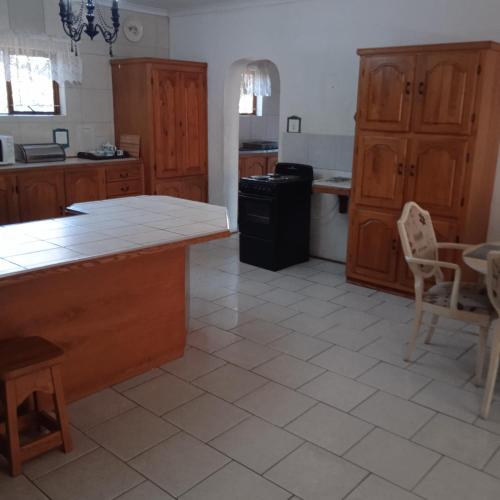 a kitchen with wooden cabinets and a white tile floor at 57 Pelican Street in St Lucia