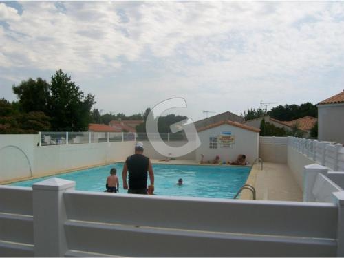 un homme et un enfant debout dans une piscine dans l'établissement Charmante maison avec piscine & accès plage, 500m de la mer, La Tranche-sur-Mer, 4 pers. - FR-1-357-274, à La Tranche-sur-Mer