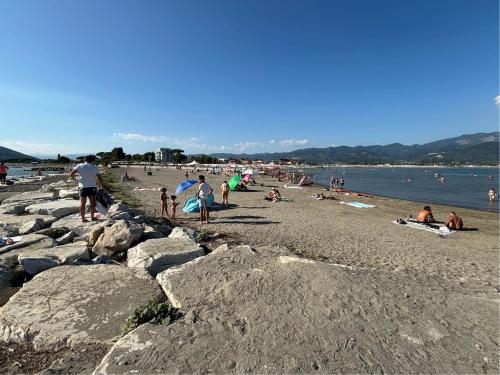 a group of people on a beach near the water at La Gio del Fosso in Ameglia