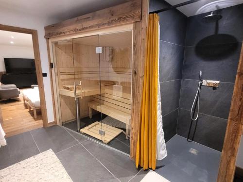La salle de bains est pourvue d'une douche avec un rideau jaune. dans l'établissement Chalet de luxe avec jacuzzi, sauna, parking et WIFI aux Gets - FR-1-598-19, aux Gets