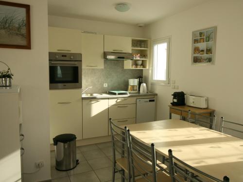 une cuisine avec une table et un comptoir dans l'établissement Maison moderne proche plage, terrasse, Wi-Fi & parking - FR-1-22-313, à La Tranche-sur-Mer