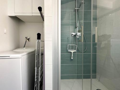 une douche avec une porte vitrée dans une salle de bain dans l'établissement Maison 5 Pers à La Palmyre - Terrasse Sud, Plage à 1000m, Commerces à 300m, Calme, WIFI, Parking - FR-1-705-21, à La Palmyre