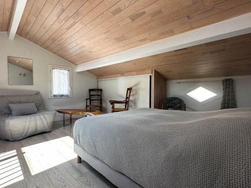 une chambre avec un lit, une table et une chaise dans l'établissement Maison 5 Pers à La Palmyre - Terrasse Sud, Plage à 1000m, Commerces à 300m, Calme, WIFI, Parking - FR-1-705-21, à La Palmyre