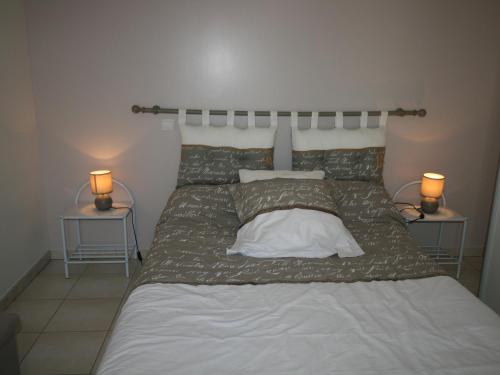 un grand lit avec deux lampes sur deux tables dans l'établissement Maison moderne proche plage, terrasse, Wi-Fi & parking - FR-1-22-313, à La Tranche-sur-Mer