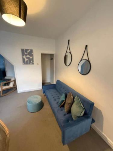 a living room with a blue couch and a blue ottoman at The Wordsworth in Barrow in Furness