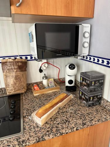 eine Küchenarbeitsplatte mit einer Mikrowelle und einem Laib Brot in der Unterkunft Casa Rural Hoces del Cabriel in Villargordo del Cabriel