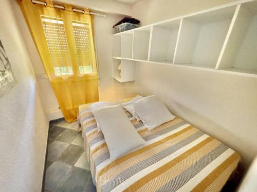 une petite pièce avec un lit et une fenêtre dans l'établissement Appartement Rez-de-Jardin 5 Pers, 2min Plage, Terrasse, Vue Mer, Garage - FR-1-723-26, au Cap d'Agde