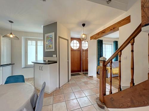 a kitchen and living room with a table and a staircase at Charmante maison 1930 centre Hennebont, déco actuelle, terrasse, jardin clos, 2 chambres, wifi inclus - FR-1-349-204 in Hennebont