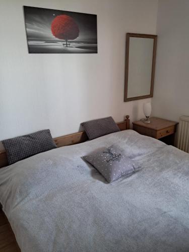 a bedroom with a bed and a mirror on the wall at Residenz Sachsensteinblick in Bad Sachsa