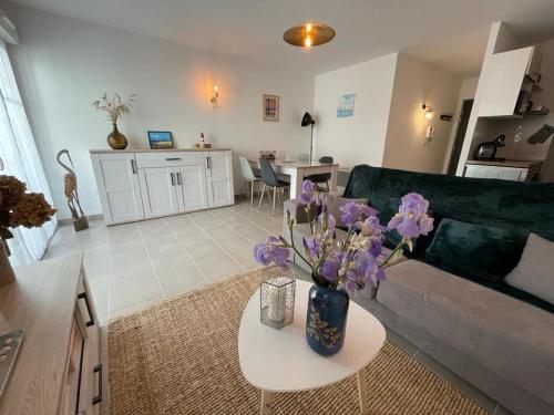 - un salon avec un canapé et une table ornée de fleurs violettes dans l'établissement Bel Appartement T2 en Centre-Ville d'Arcachon avec Balcon, à 200m de la Plage et Proche de la Gare - FR-1-474-243, à Arcachon