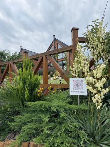 a garden with flowers in front of a wooden fence at Czereśniowe Wzgórze Sandomierz jakuzzi in Sandomierz