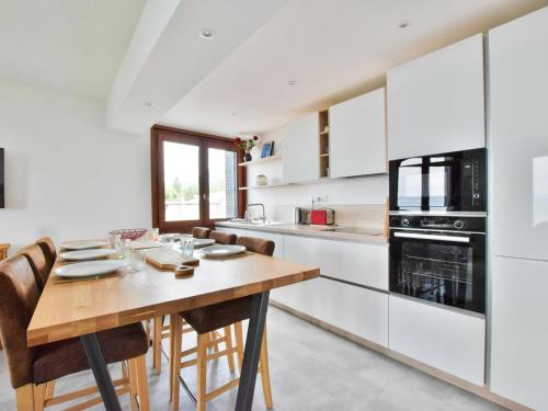 une cuisine avec une table en bois et quelques chaises dans l'établissement Charmant appartement 4 pers avec balcon et vue lac, proche plage à Neuvecelle - FR-1-498-18, à Neuvecelle