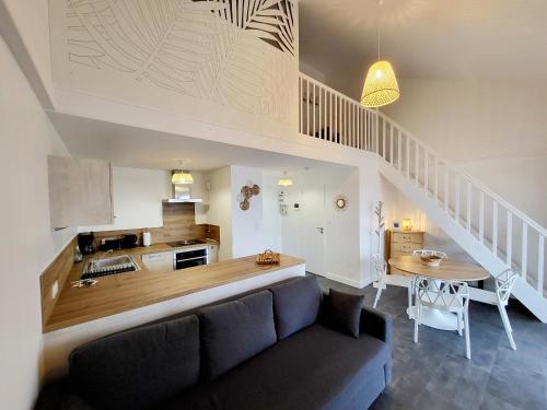 un salon avec un canapé bleu et une cuisine dans l'établissement T1 Bis Moderne Refait à Neuf, Plage à 250m - Quartier Arago - FR-1-92-577, à Les Sables-dʼOlonne