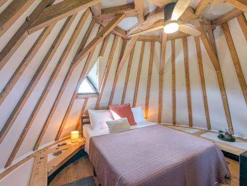 - une chambre mansardée avec un lit et une fenêtre dans l'établissement Toujours Dimanche Windmill Retreat, à Loubès-Bernac
