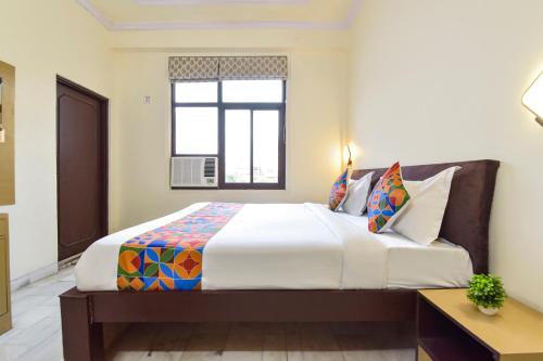 a bedroom with a large white bed with a window at FabHotel Silver Stay 04 - Ahinsa circle in Jaipur