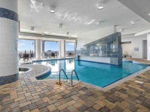 a large swimming pool with blue water in a building at Oceanfront Luxury King Suite at Oceans One Resort in Myrtle Beach